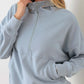 Woman wearing Tasha Apparel Half Zip Drawstring Mock Neck Hoodie in solid color with long sleeves and a front pocket.