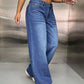 Woman wearing wide leg jeans with pockets and white sneakers, showcasing a fashion-forward look.