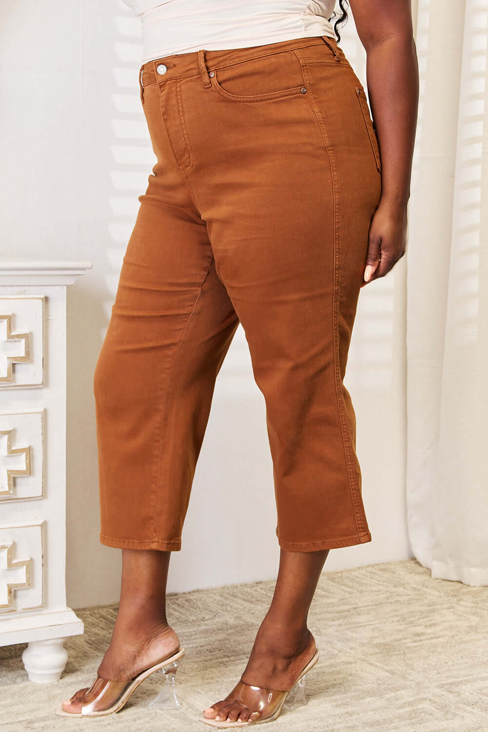 Woman wearing Judy Blue Jeans tummy control wide cropped pants in brown, paired with clear heels, showing the front and side view.