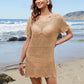 Stylish woman in openwork sheer cover-up on the beach, showcasing summer vibes and trendy fashion.