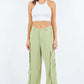 Woman wearing Linen Wide Leg Cargo Pants with cargo pockets and a white crop top against a plain background