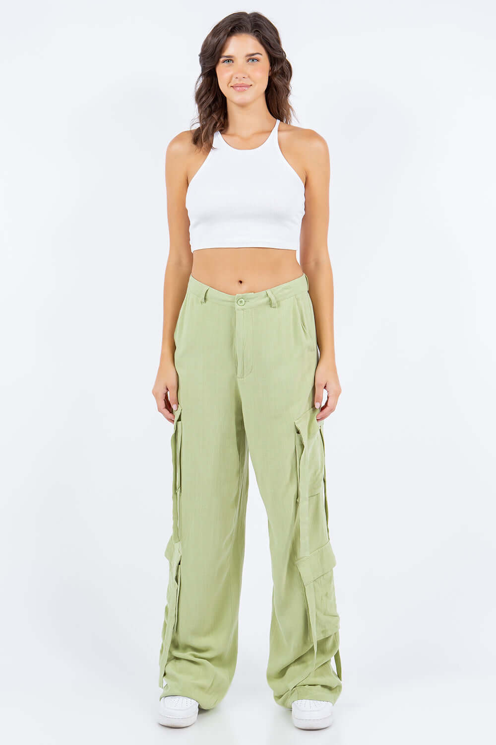 Woman wearing Linen Wide Leg Cargo Pants with cargo pockets and a white crop top against a plain background