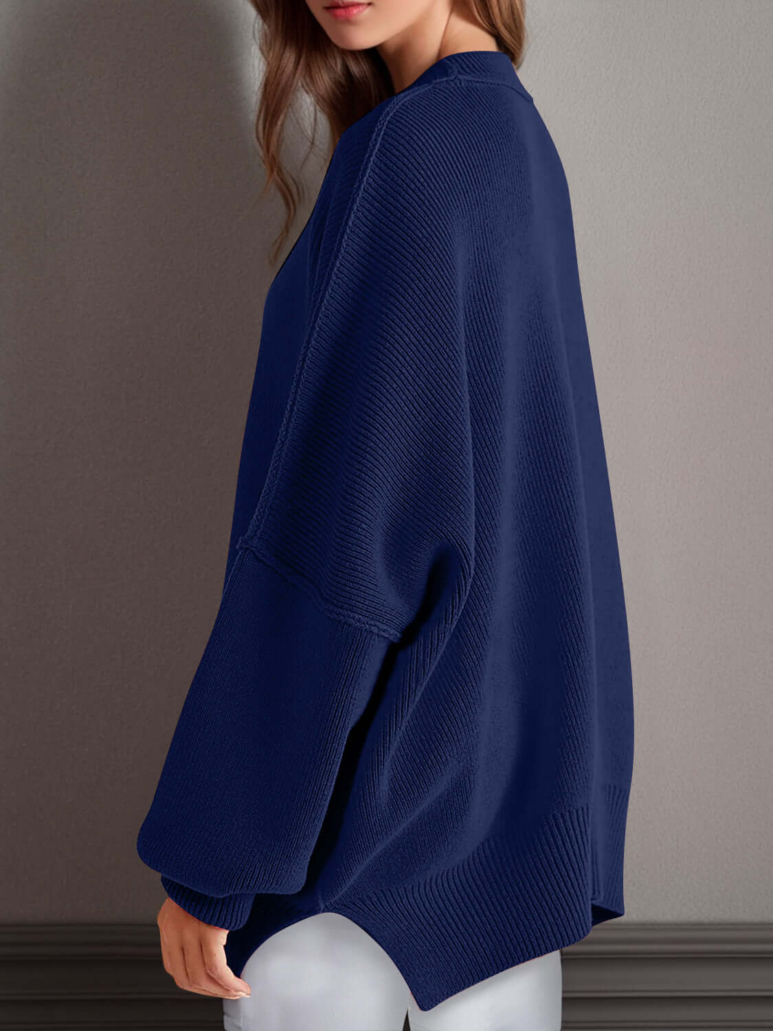 Woman wearing Double Take Side Slit Round Neck Long Sleeve Sweater in navy blue from behind.