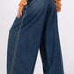 Wide-leg denim jeans with high waist and dark blue wash, shown from the back on a model wearing an orange sweater