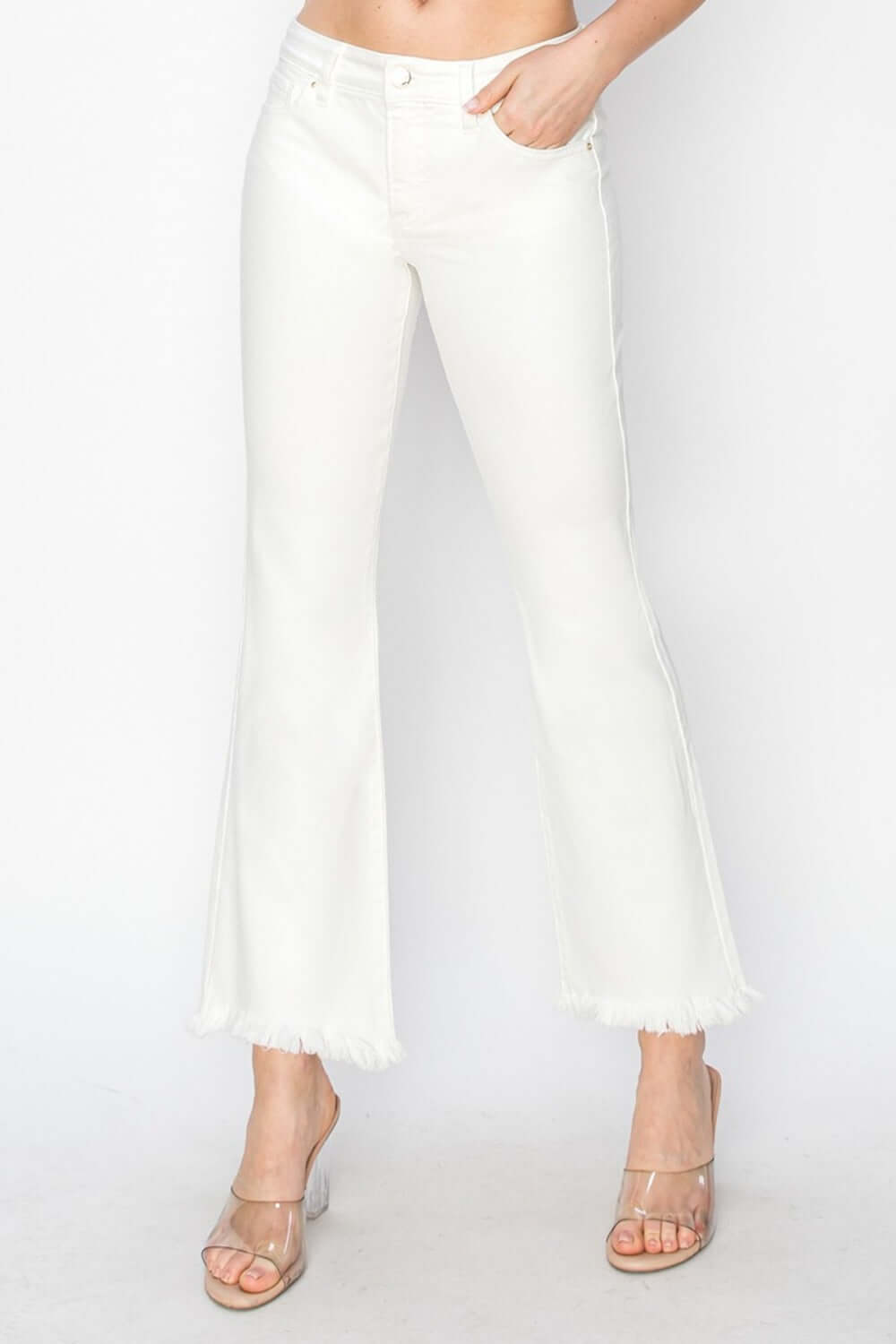 White tummy control crop flare pants with raw step hem and pockets, enhancing silhouette.