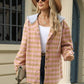 Woman wearing Bella Road Plaid Long Sleeve Hooded Jacket with white top, jeans, and hat, standing outside building