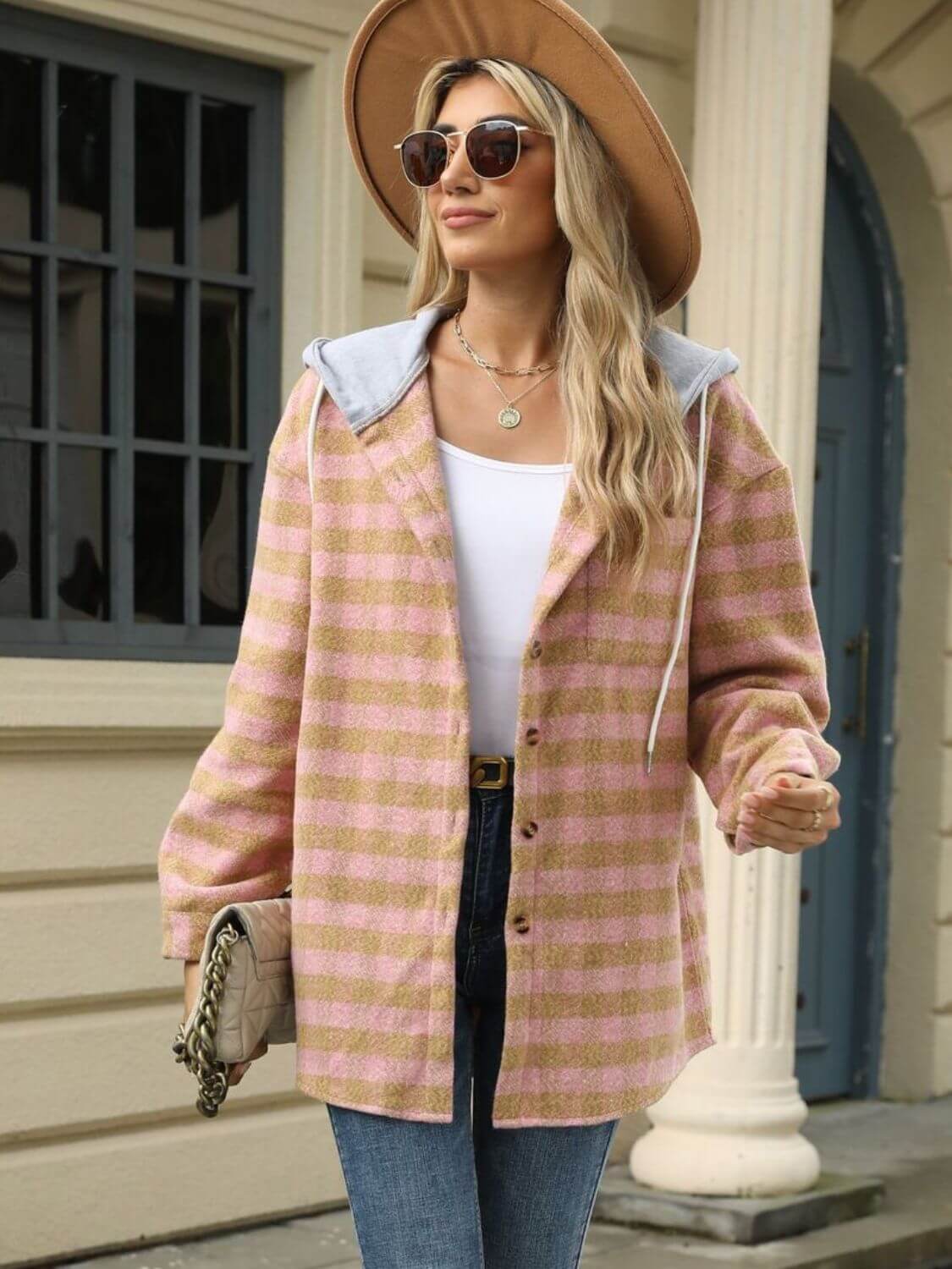 Woman wearing Bella Road Plaid Long Sleeve Hooded Jacket with white top, jeans, and hat, standing outside building