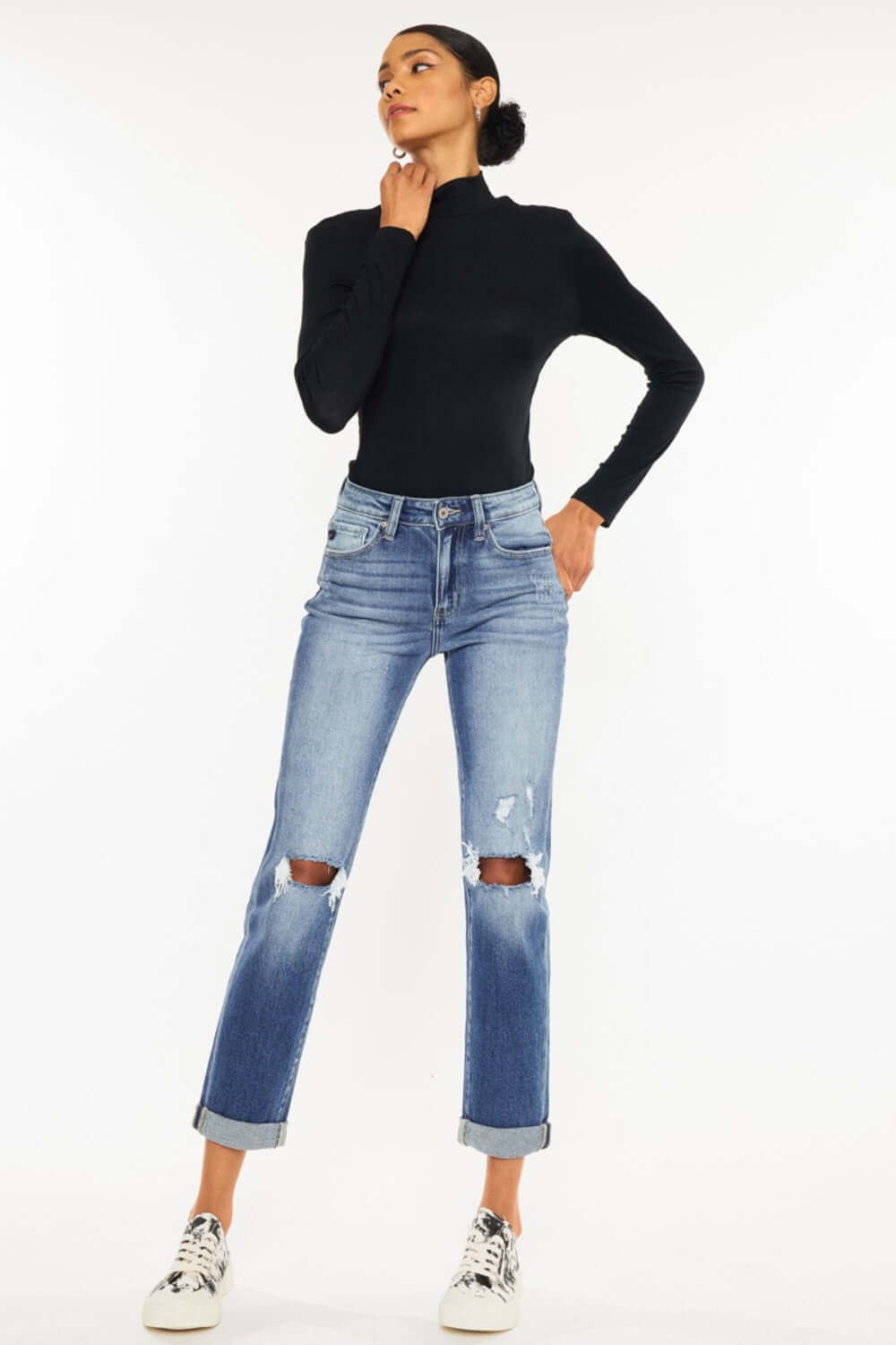 Woman modeling high waist distressed hem detail cropped straight jeans with edgy, worn-in look, paired with black top and sneakers