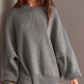 Woman wearing Double Take Side Slit Round Neck Long Sleeve Sweater in gray, featuring a playful side slit design and relaxed fit.