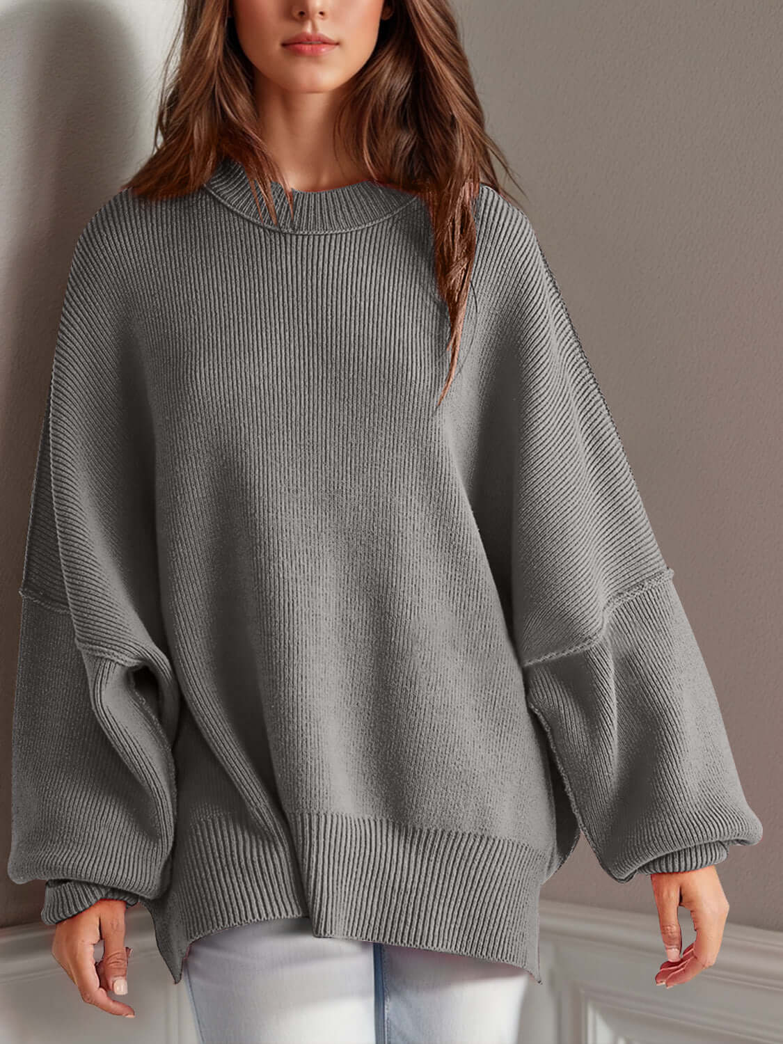 Woman wearing Double Take Side Slit Round Neck Long Sleeve Sweater in gray, featuring a playful side slit design and relaxed fit.