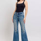 Model showcasing Judy Blue Mid Rise Tummy Control Vintage Wash Jeans paired with a black tank top, highlighting retro style.