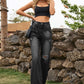 Woman wearing Bella Road Distressed Jeans with pockets in black, styled with a crop top and sunglasses, outdoors.