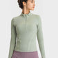 Model showcasing the Millennia Half Zip Thumbhole Sleeve Sports Top in mint green, perfect for workouts and yoga.