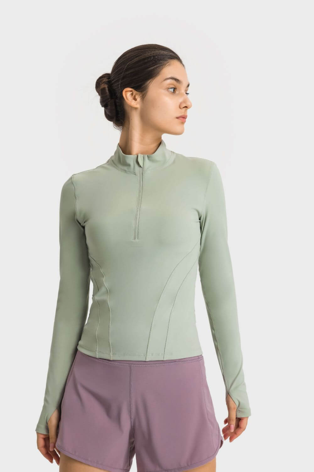 Model showcasing the Millennia Half Zip Thumbhole Sleeve Sports Top in mint green, perfect for workouts and yoga.