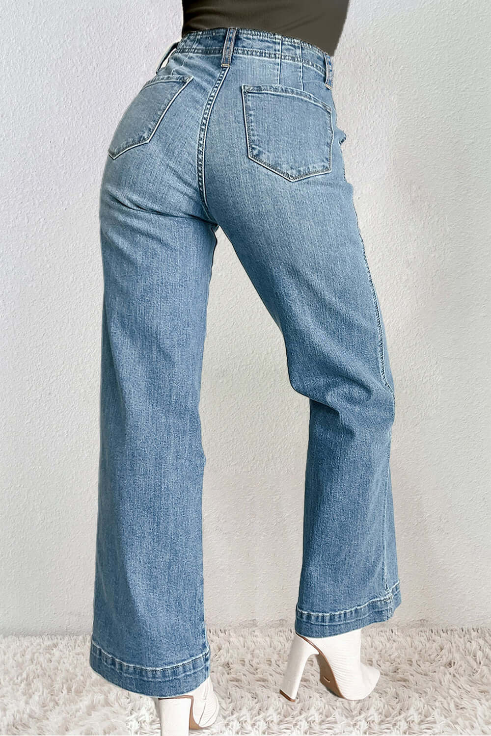 Woman wearing petite straight jeans with pockets and button details, showcasing a stylish back view. Perfect for casual occasions.