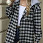 Woman wearing Bella Road Drawstring Plaid Long Sleeve Hooded Jacket holding a coffee cup