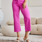 Woman wearing RFM Jeans Crop Chloe Full Size Tummy Control High Waist Raw Hem Jeans in bright pink, paired with white heeled sandals.