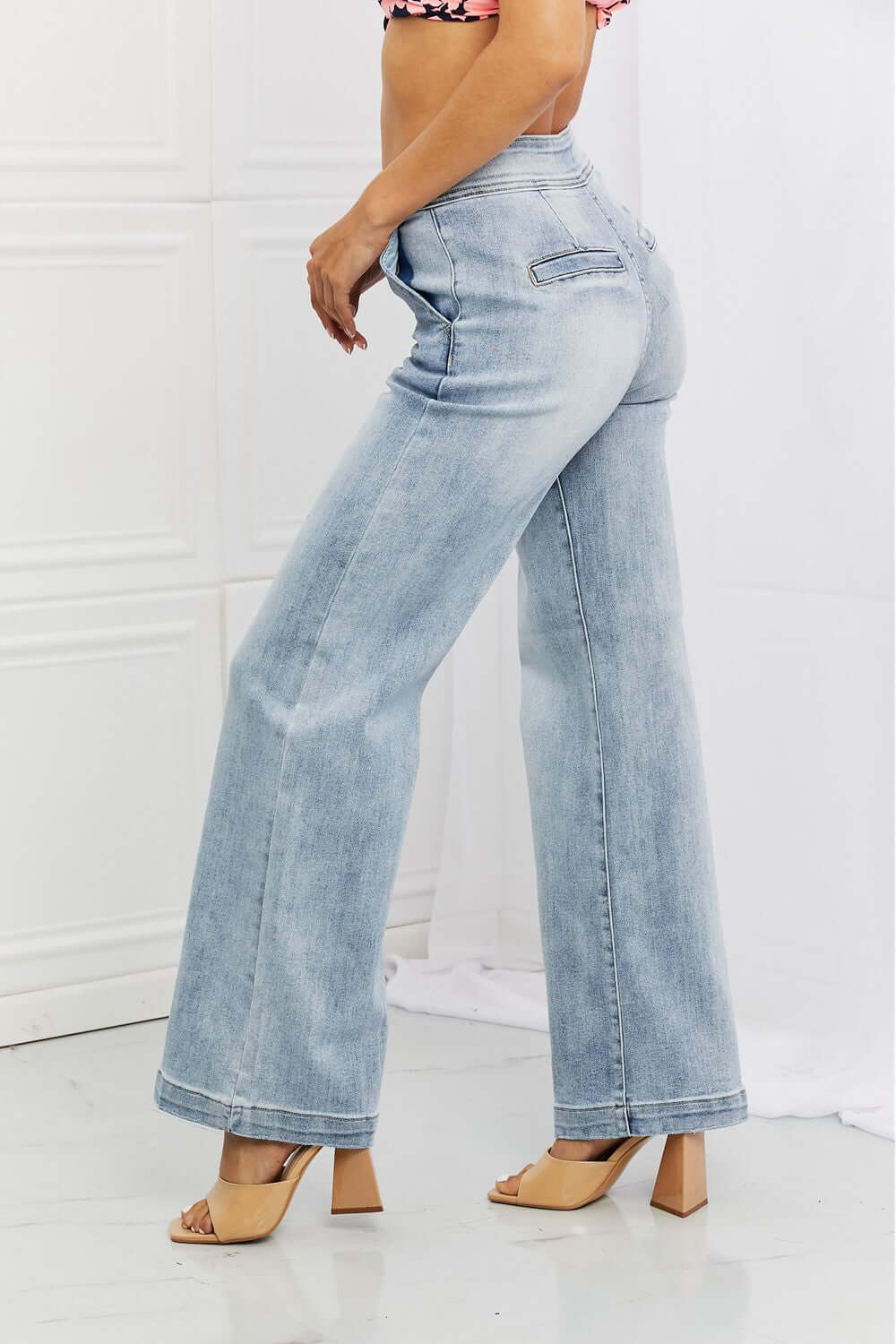 Model wearing Risen high-waisted Luisa Wide Flare Jeans with pockets, showcasing casual style and light wash denim袢