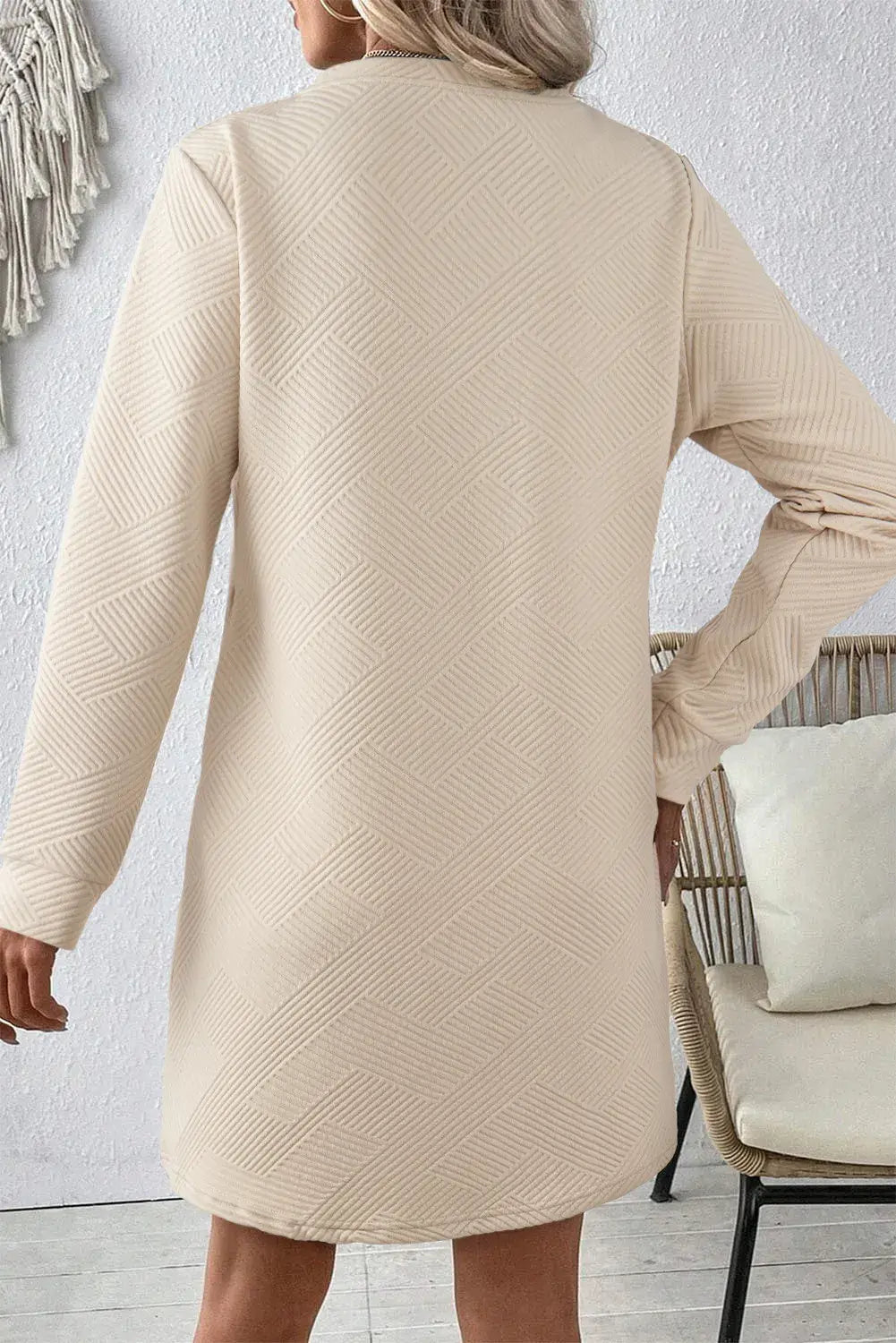 Back view of Bella Road beige textured long sleeve mini dress, featuring a subtle herringbone pattern and a comfortable fit.