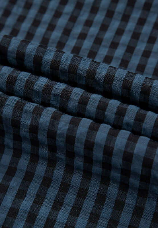 Blue and black plaid fabric close-up of Bella Road wide leg overalls, showcasing stylish and trendy material pattern.