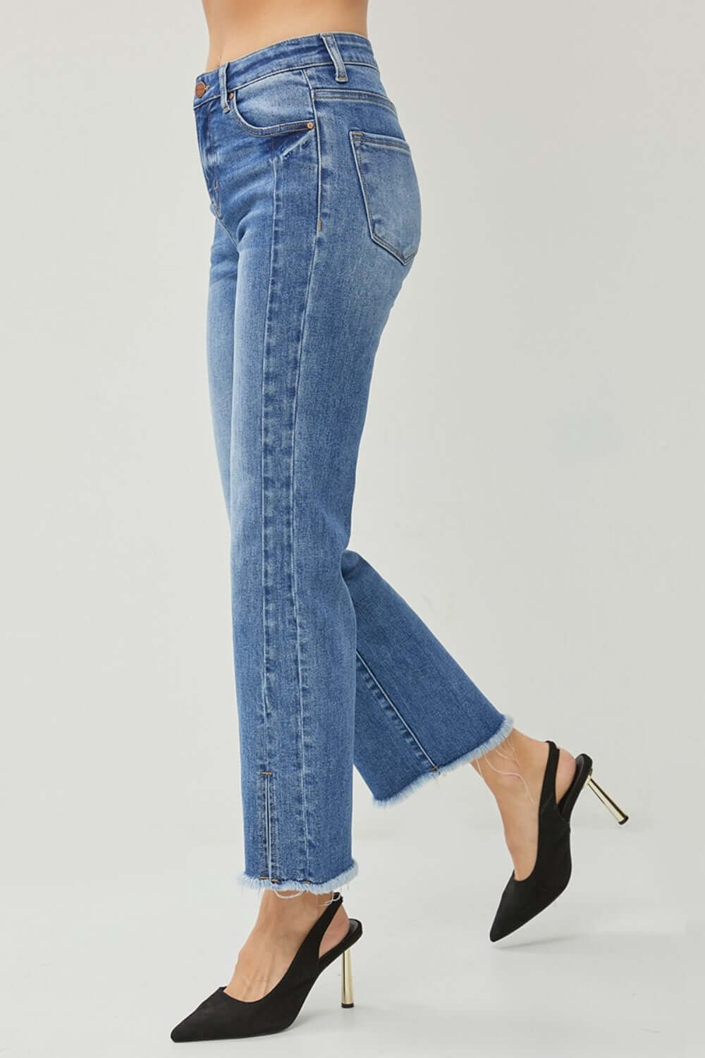 High Waist Raw Hem Slit Straight Jeans by Risen Jeans, side view with black heeled shoes, trendy and stylish denim for a flattering fit.