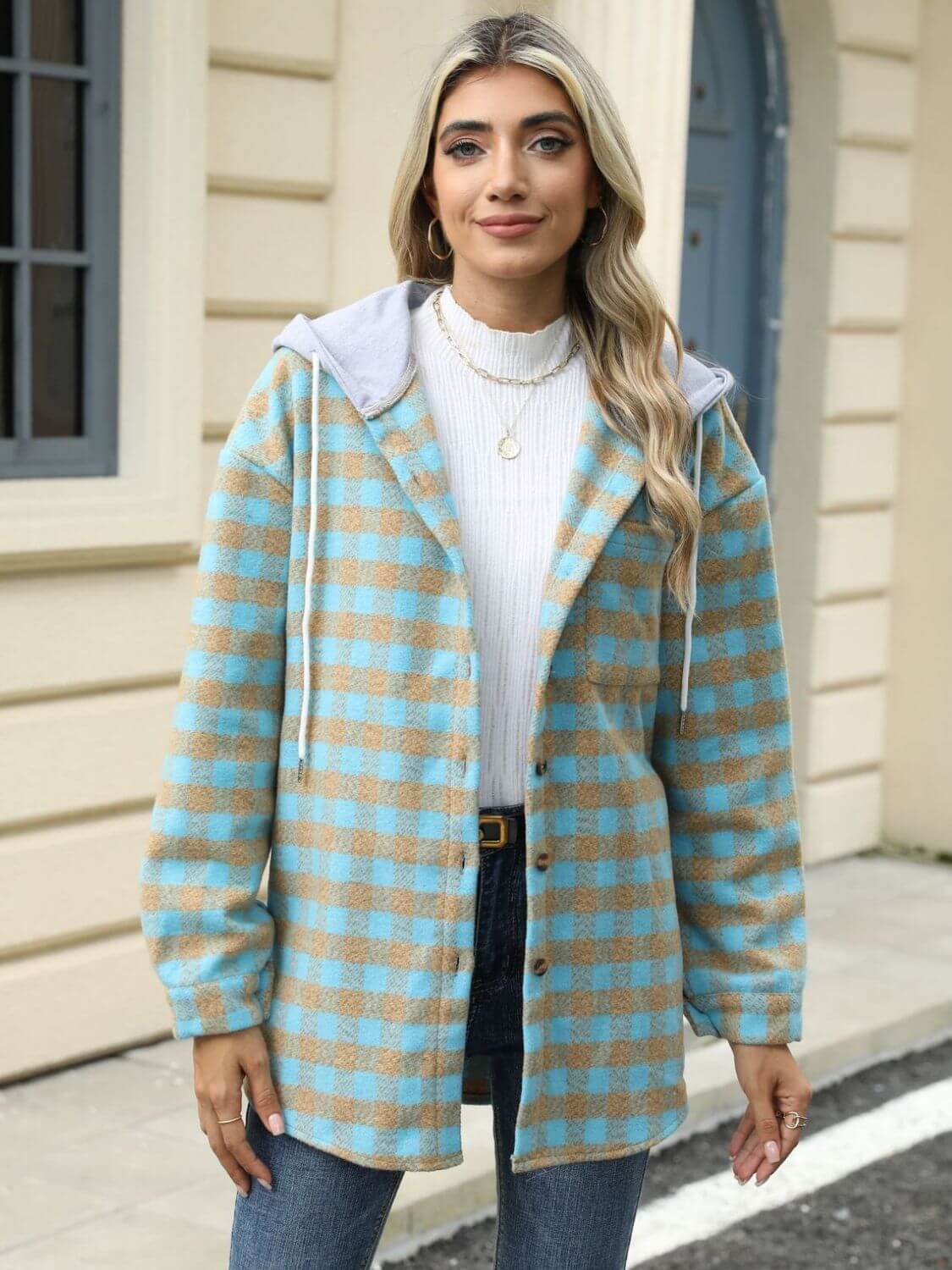 Woman wearing Bella Road Drawstring Plaid Long Sleeve Hooded Jacket in beige and blue outside of a building