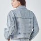 Woman wearing RISEN full size button down cropped denim jacket rear view showing stylish and versatile outerwear piece