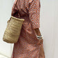 Woman wearing Bella Road Tied Button Up Three-Quarter Sleeve Dress with woven bag and bracelets