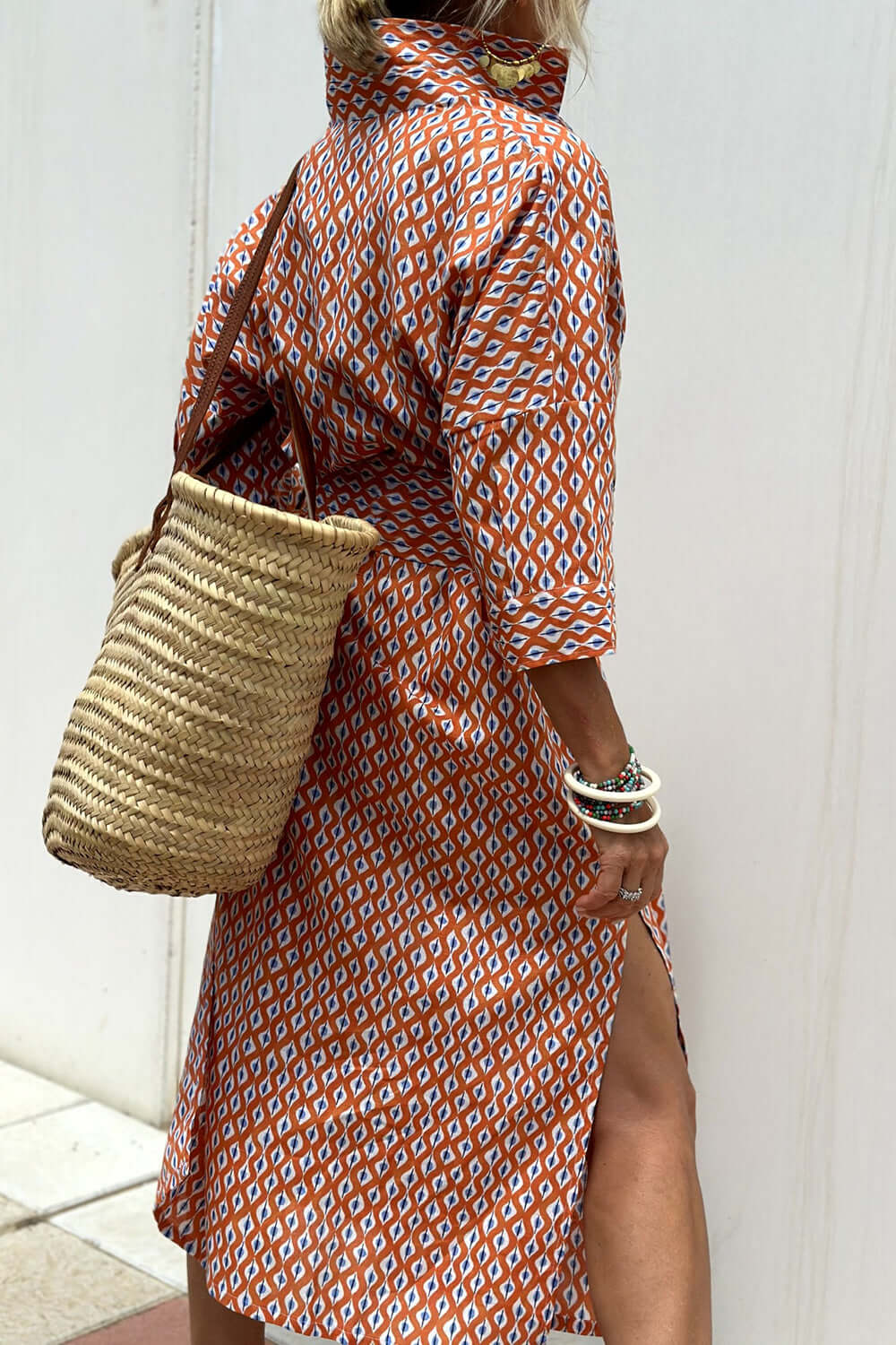 Woman wearing Bella Road Tied Button Up Three-Quarter Sleeve Dress with woven bag and bracelets