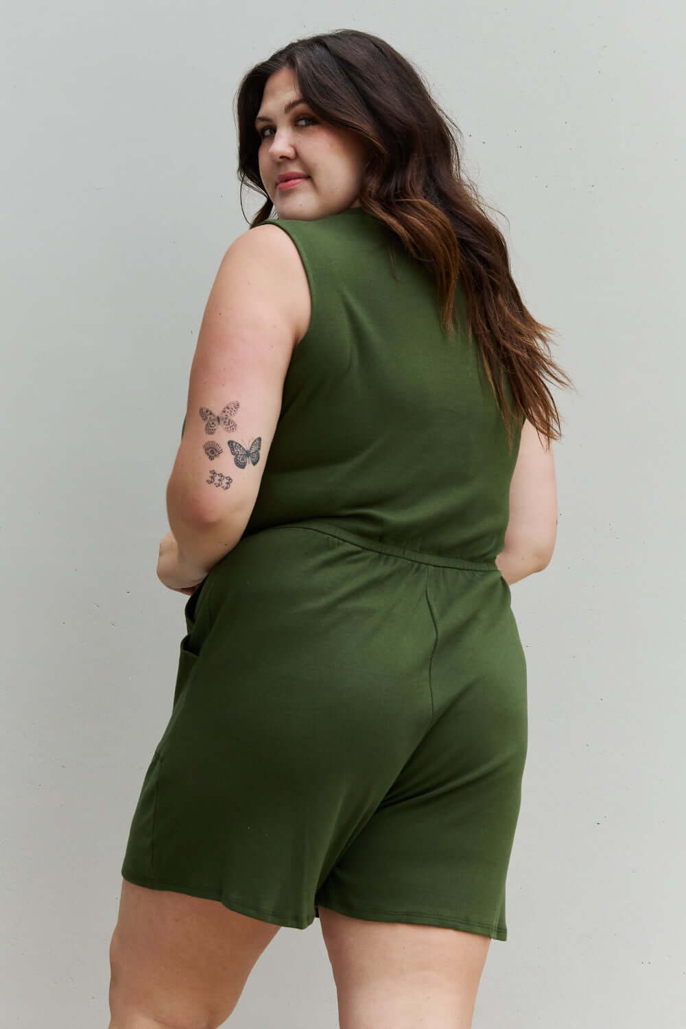 Woman wearing Forever Yours V-Neck Sleeveless Romper in Army Green, showcasing the back design and comfortable fit.