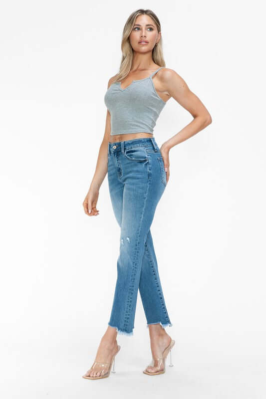 Model wearing bytos Raw Hem Distressed Mid Rise Crop Jeans paired with a gray crop top and stylish heels.