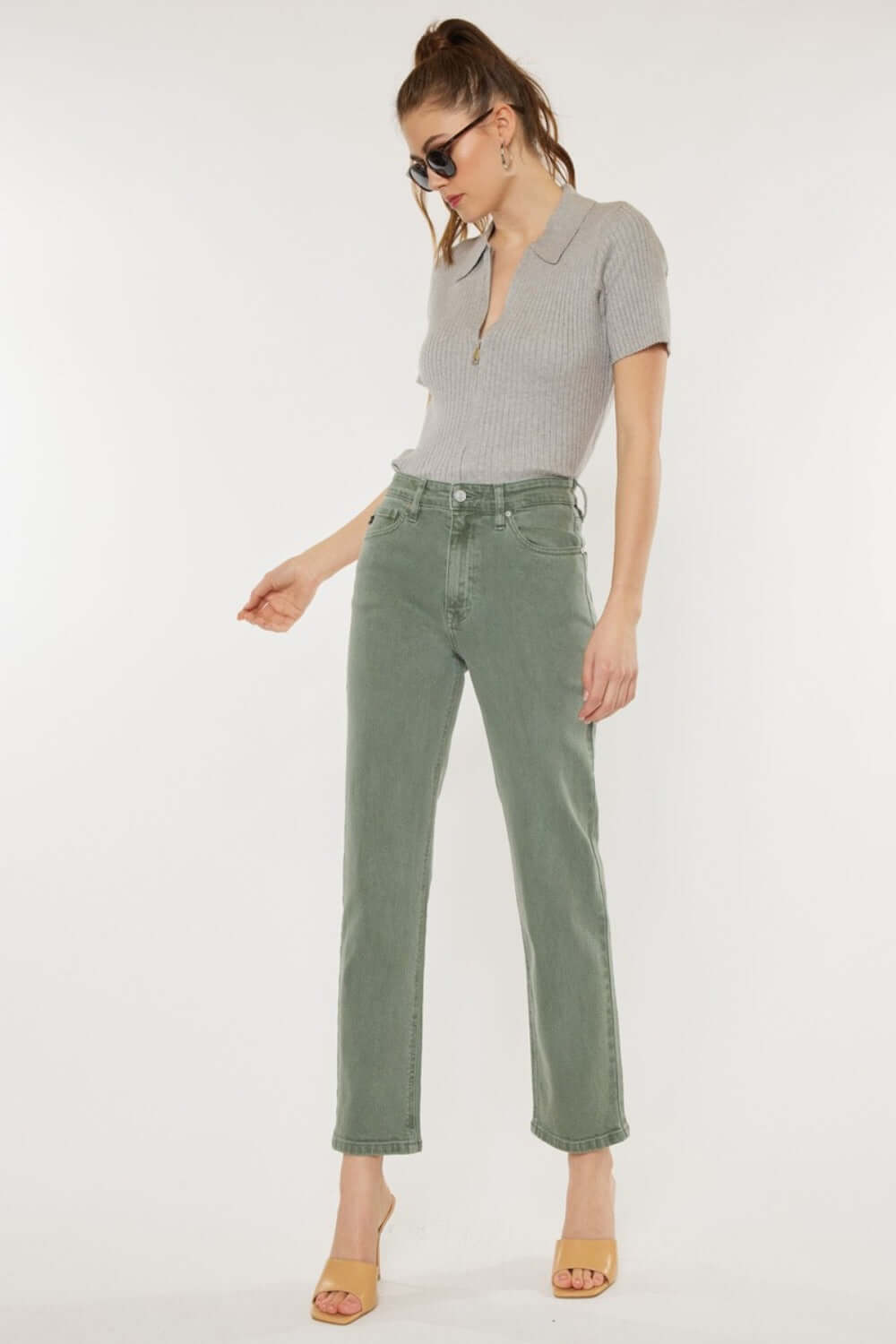 Woman wearing Kancan Ultra High Rise Straight Jeans in olive, paired with a chic top and heels for a vintage-inspired look.