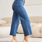 Woman wearing Crop Chloe Tummy Control High Waist Raw Hem RFM Jeans with heels in a stylish indoor setting