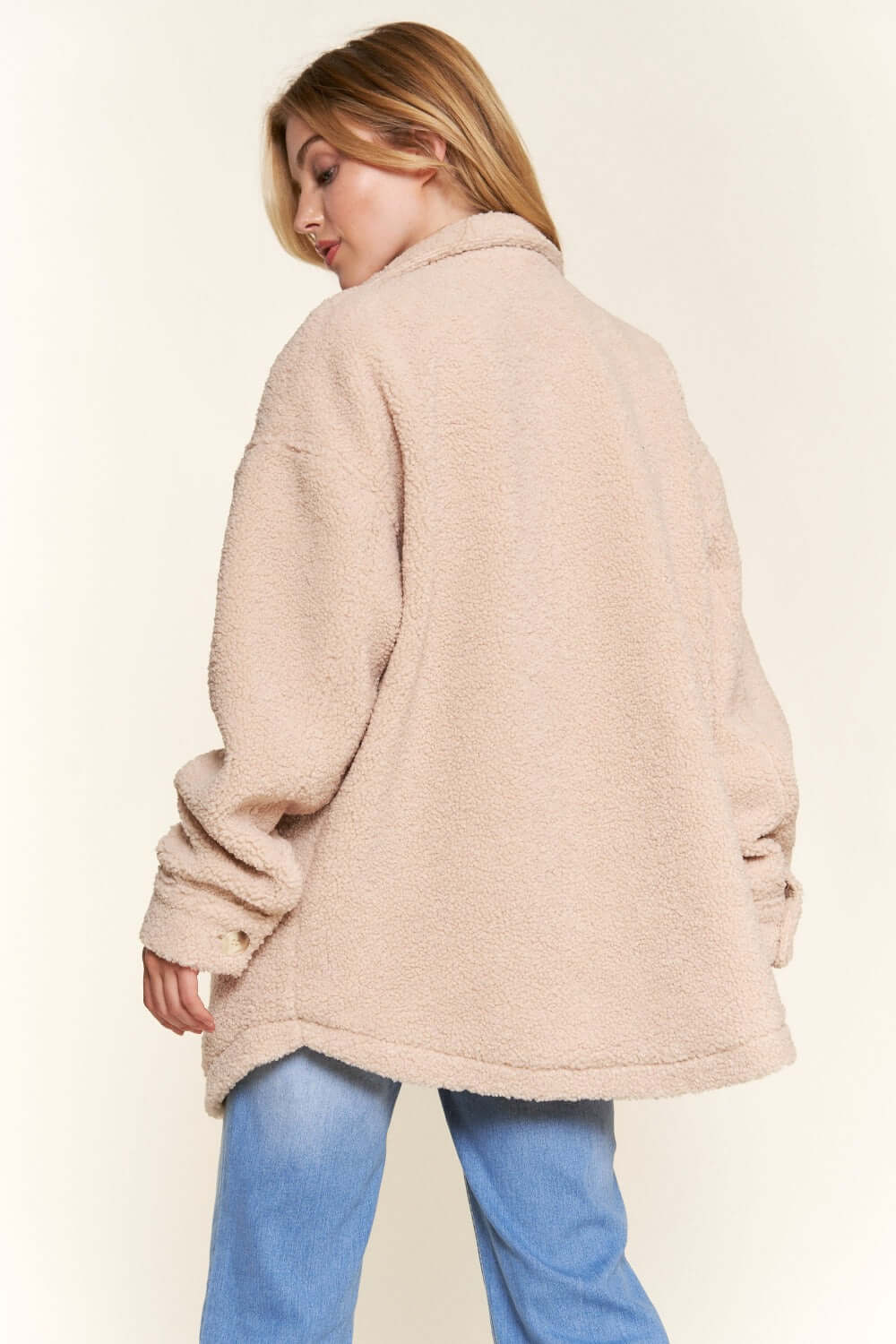 Cozy teddy sherpa shacket with button-down design and curved hem, perfect for layering in style, shown in casual outfit.