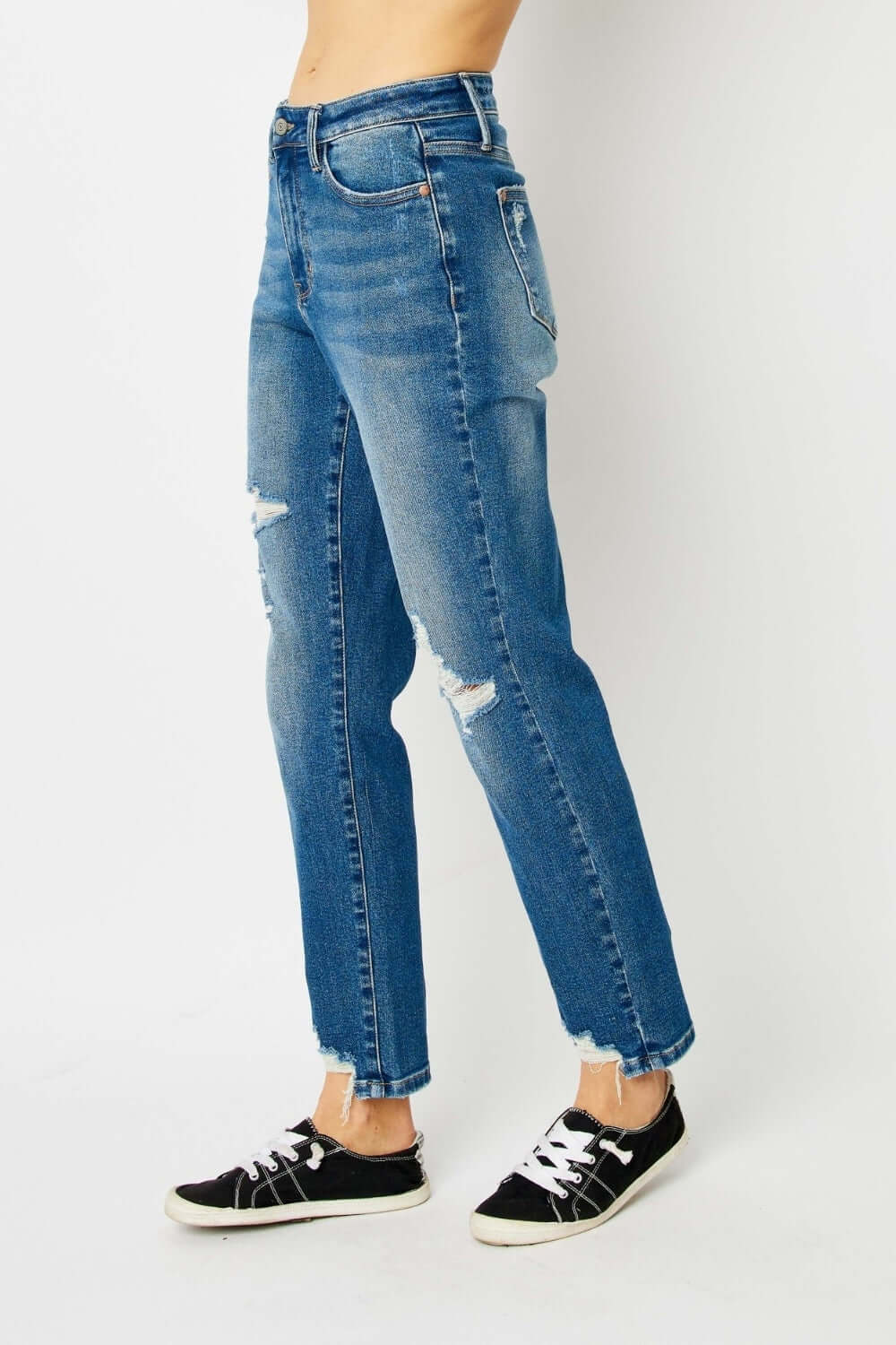 Distressed Slim Judy Blue Jeans with ripped details and a flattering fit, paired with black sneakers.