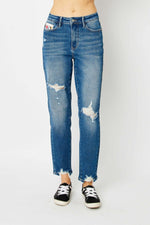 Distressed slim jeans by Judy Blue Jeans with trendy design, shown with sneakers for a relaxed, stylish look.