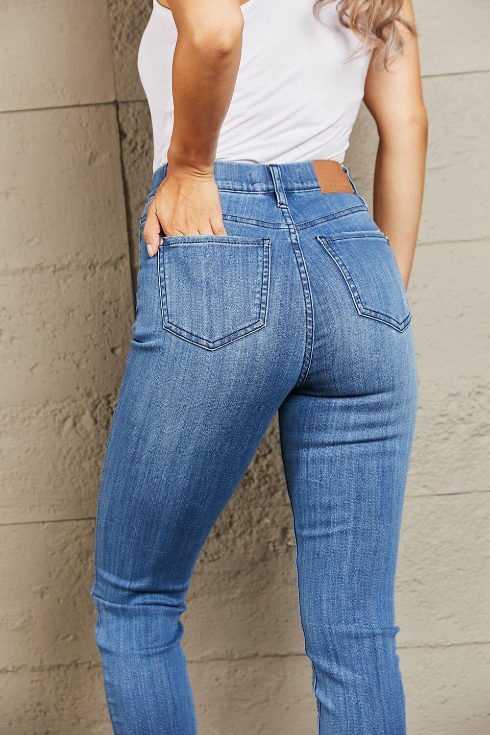 Rear view of model wearing Janavie high waisted pull-on skinny jeans with release hem detailing and premium stretch denim fabric.