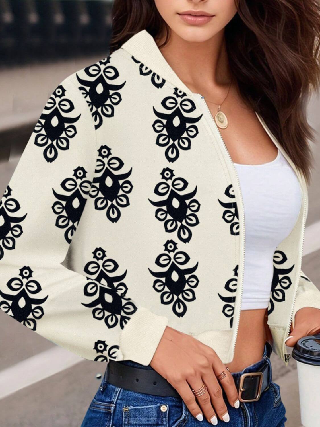 Woman wearing Bella Road Printed Zip Up Long Sleeve Jacket with playful black print over a white base, stylish and trendy casual wear.