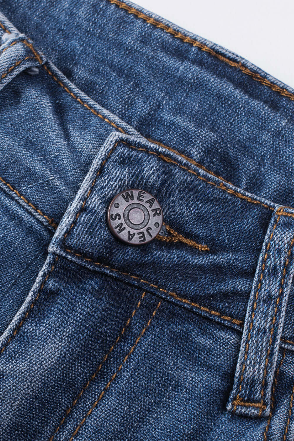 Close-up of button and waistband detail on Bella Road Distressed Straight Jeans with Pockets