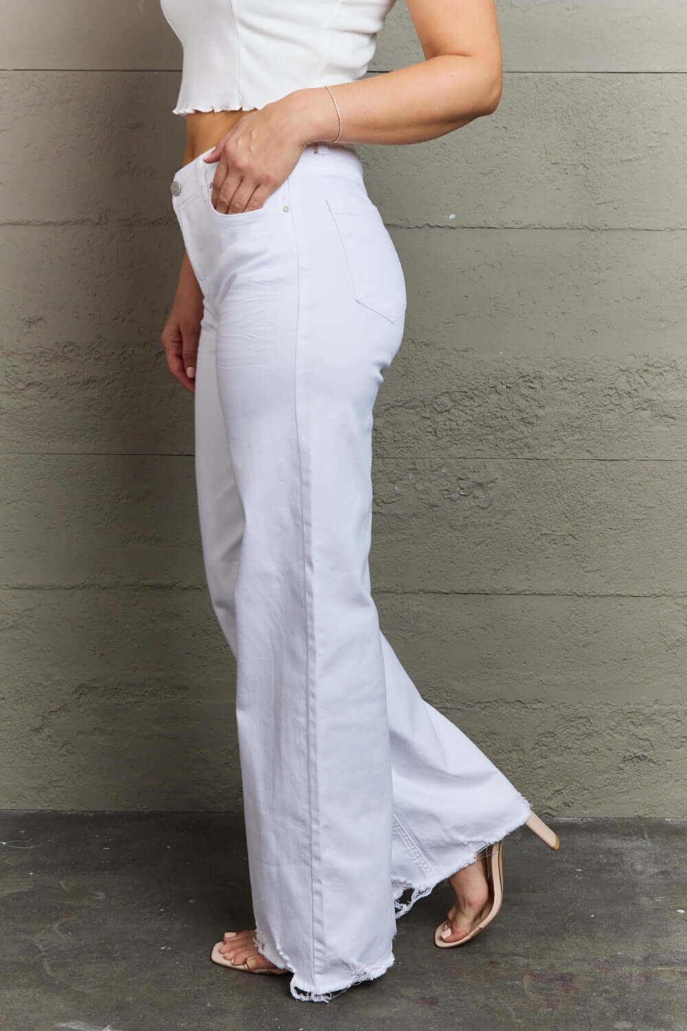 Fashionable woman wearing Raelene High Waist Wide Leg Jeans in White by Risen Jeans, showcasing chic and comfortable wide-leg design.