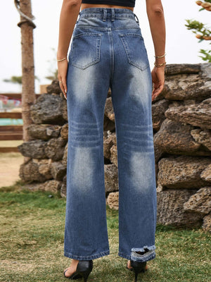 Woman wearing Bella Road Distressed Jeans with pockets in navy, showcasing a stylish back view against an outdoor backdrop.