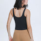 Woman in sleek black v neck active tank top and leggings, showcasing a stylish workout look from the back.