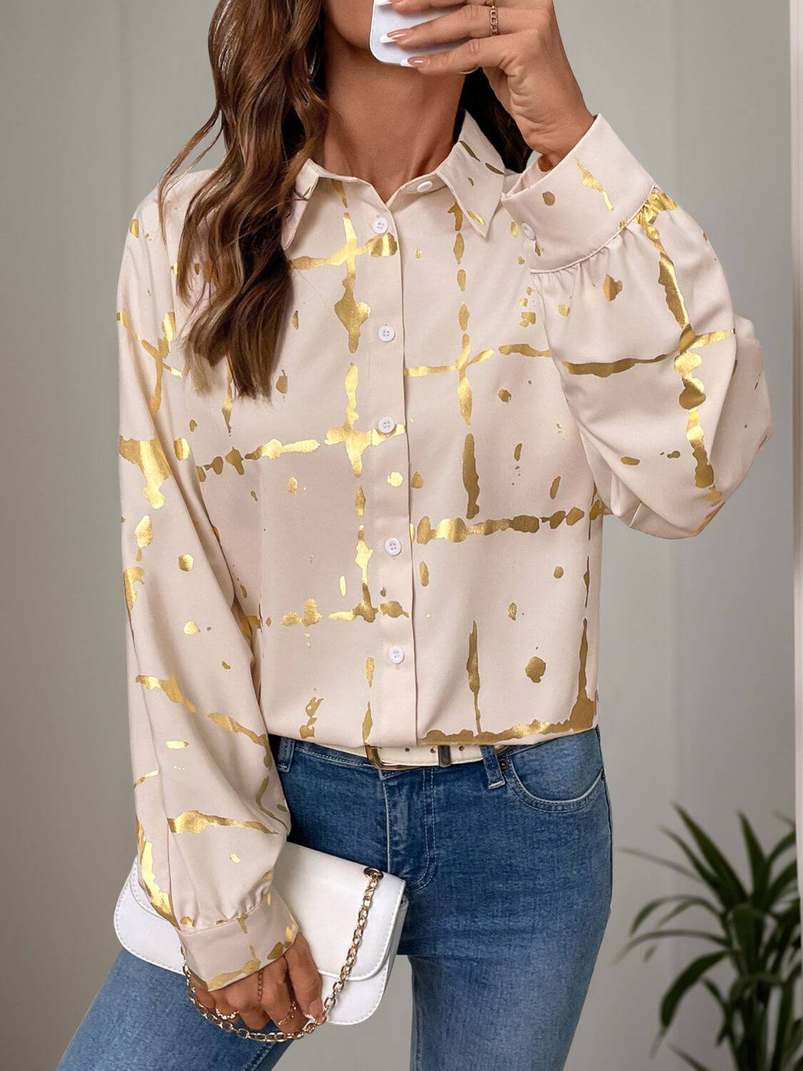 Woman wearing Perfee printed collared neck long sleeve shirt in tan with gold accents, paired with blue jeans.