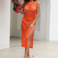 Woman wearing a bright orange Cutout Openwork Round Neck Sleeveless Cover-Up dress with a side slit outdoors