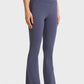 Model showcasing Millennia Elastic Waist Flare Yoga Pants in navy, designed for comfort and style during workouts.