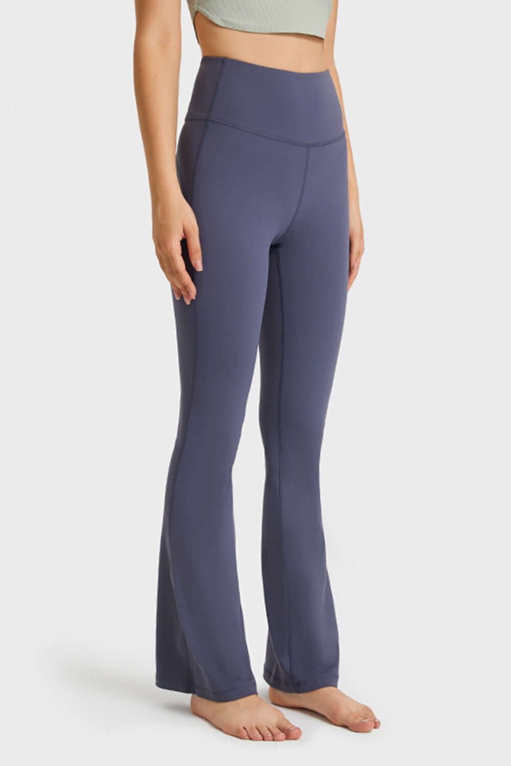 Model showcasing Millennia Elastic Waist Flare Yoga Pants in navy, designed for comfort and style during workouts.