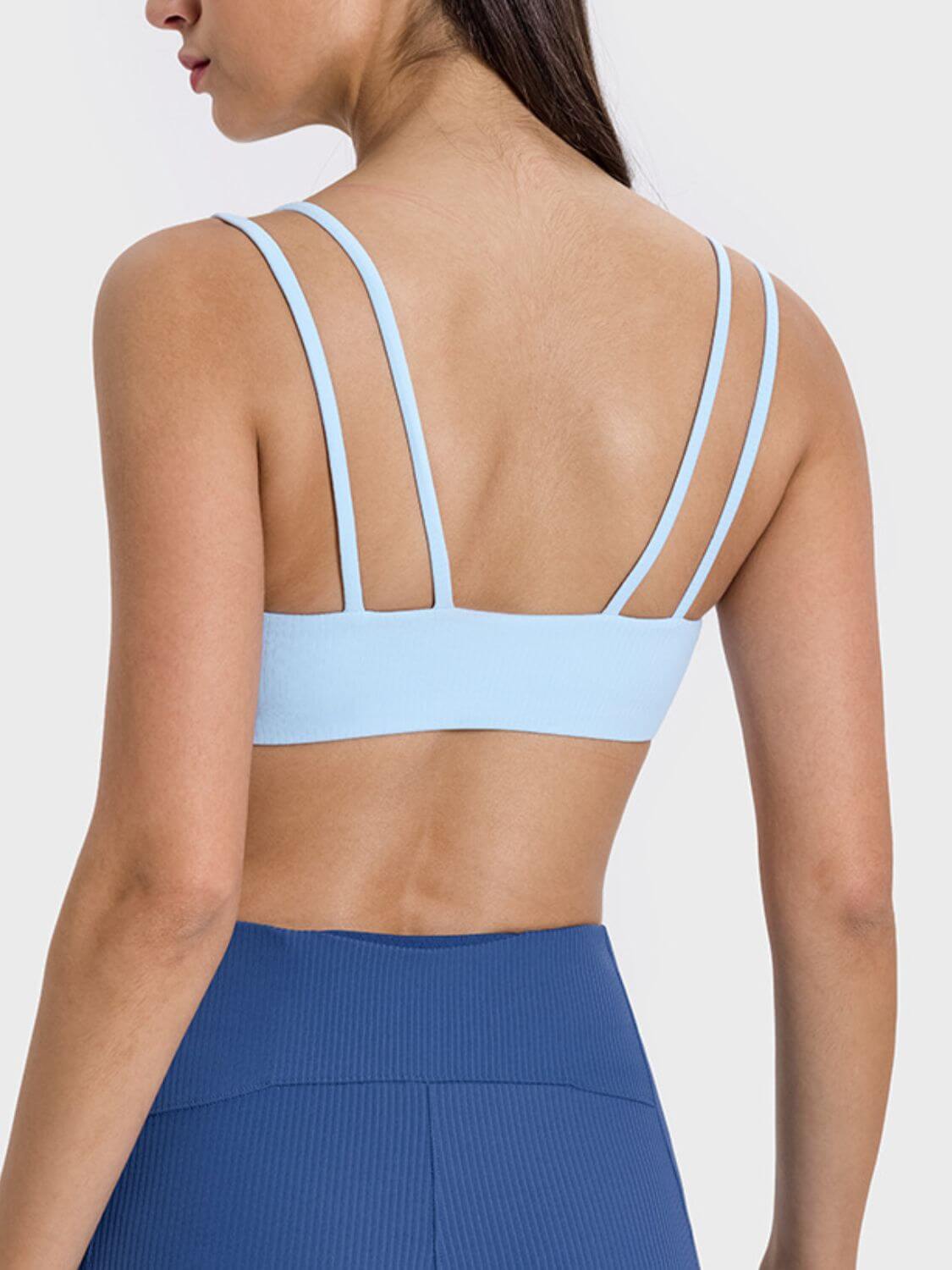 Back view of a model wearing a light blue double strap cami, perfect for workouts and casual wear.