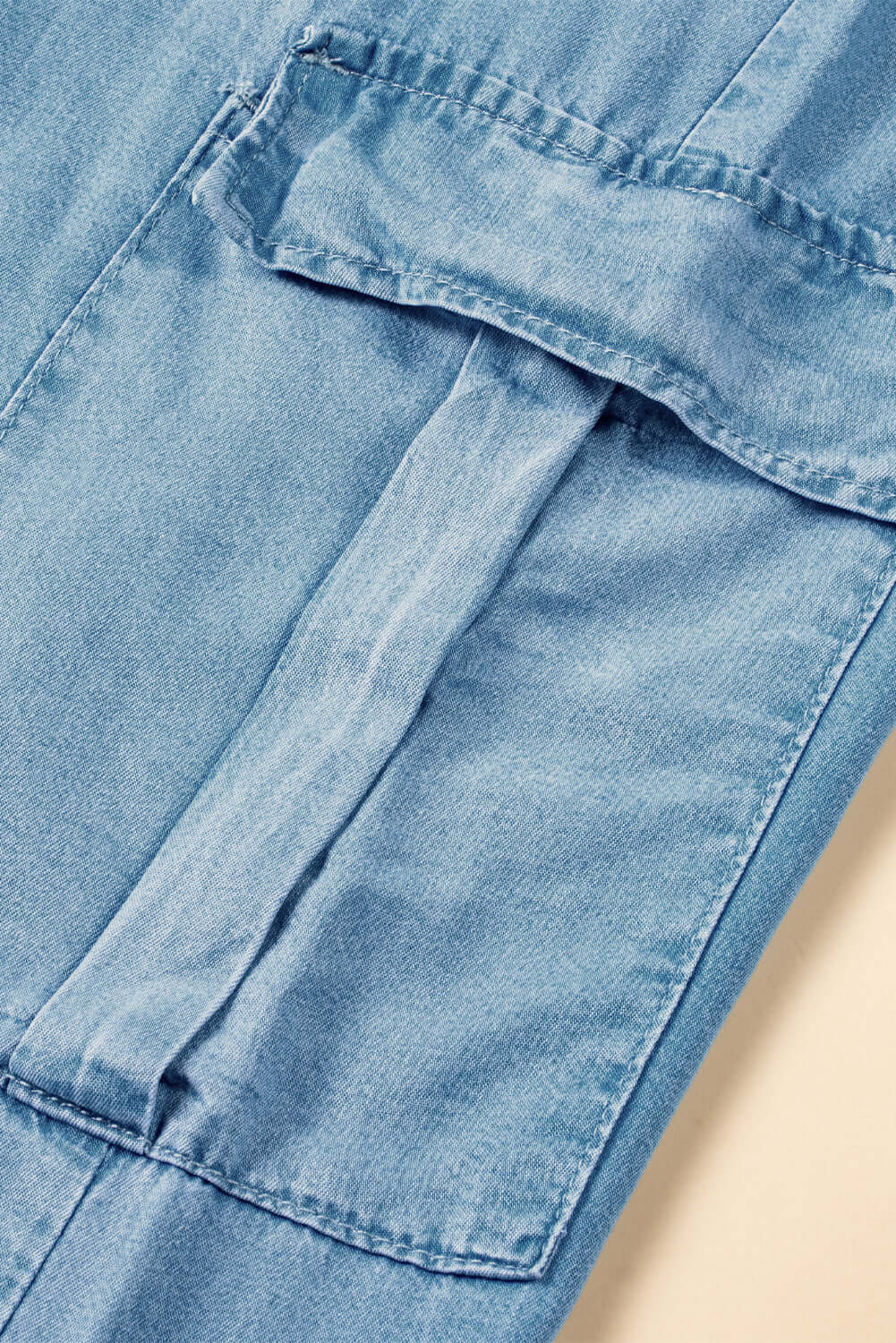 Close-up of Bella Road Denim Cargo Pocket showing light wash fabric and drawstring detail for trendy wide leg jeans.