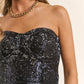 Woman wearing J.NNA sequin strapless bustier top, showcasing a glamorous fitted silhouette perfect for chic party looks.