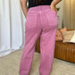 Back view of woman wearing RFM Full Size High Rise Garment Dye Wide Leg Jeans in rich pink color, highlighting relaxed fit and two back pockets.